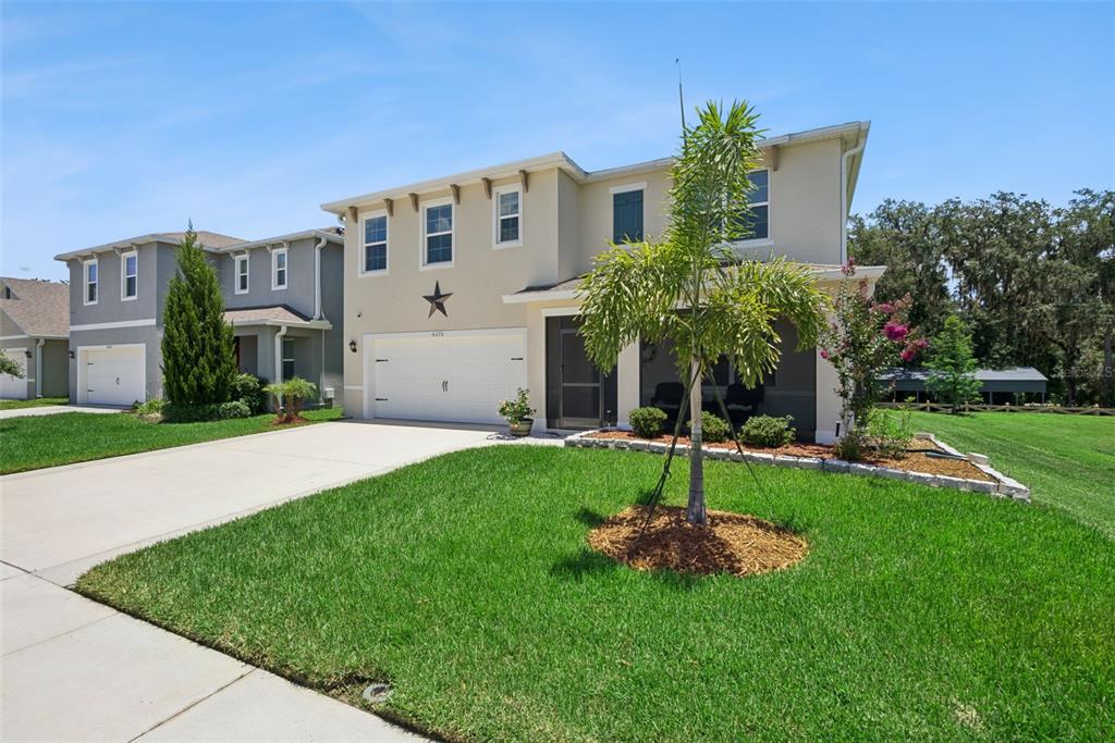 A two-story suburban house with a two-car garage, a screened porch, and a front lawn — 4076 SAPSUCKER LOOP, SANFORD, FL