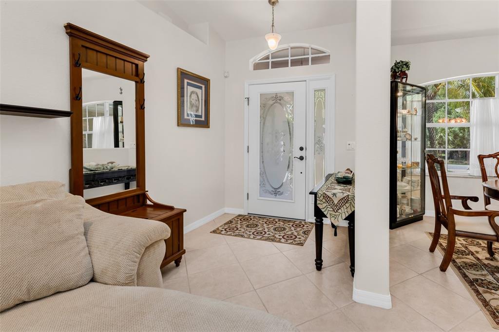An entryway features tile flooring, a wooden coat rack with a mirror, and a front door — 131 SUNDIET STREET, PORT CHARLOTTE, FL
