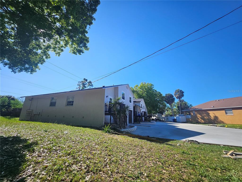 A side view of a multi-unit residential building with a concrete driveway and grassy yard — 5802 MOHR LOOP UNIT 5802 5804 5806 5808, TAMPA, FL