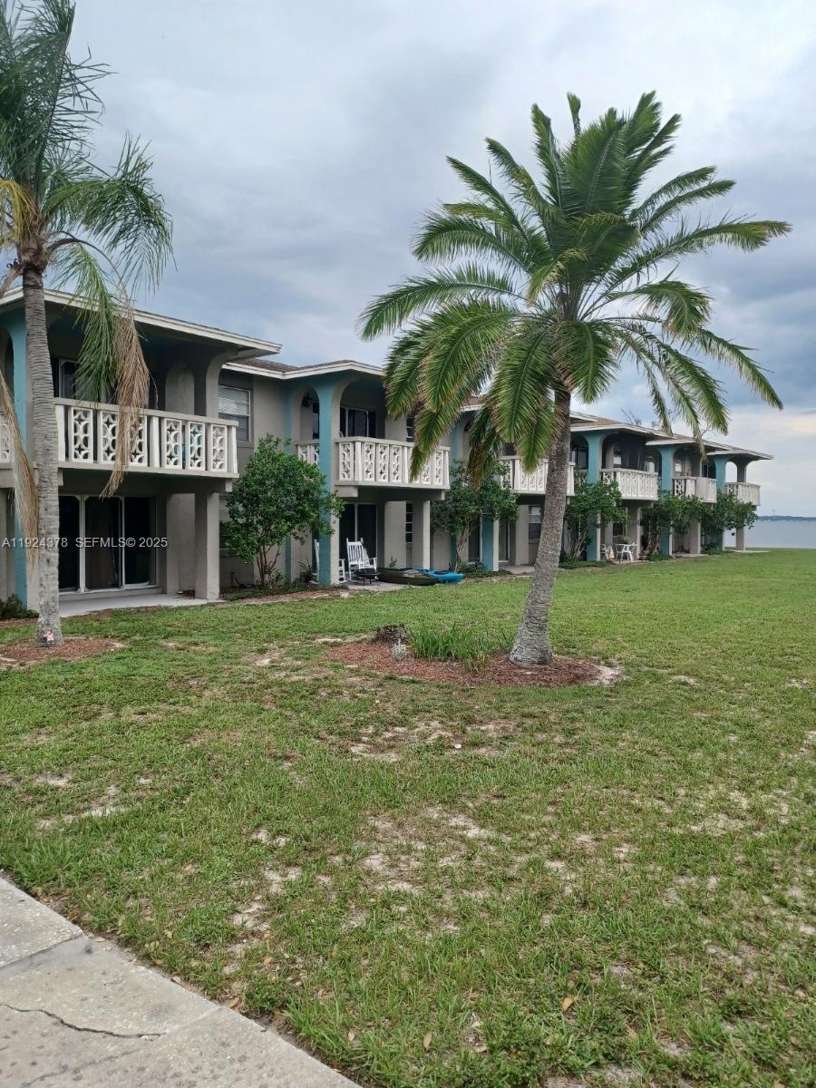 A two-story apartment building with balconies faces a grassy lawn and a body of water — 1015 LAKEVIEW DRIVE, Sebring FL 33870, SEBRING, FL