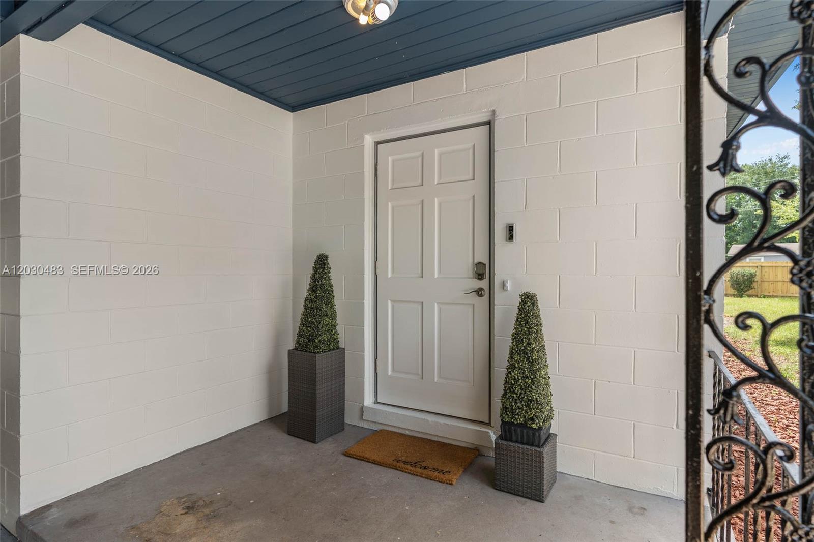 A white front door sits on a covered porch with concrete walls and flooring — 4255 Wee Street # 4255, Mount Dora FL 32757, MOUNT DORA, FL