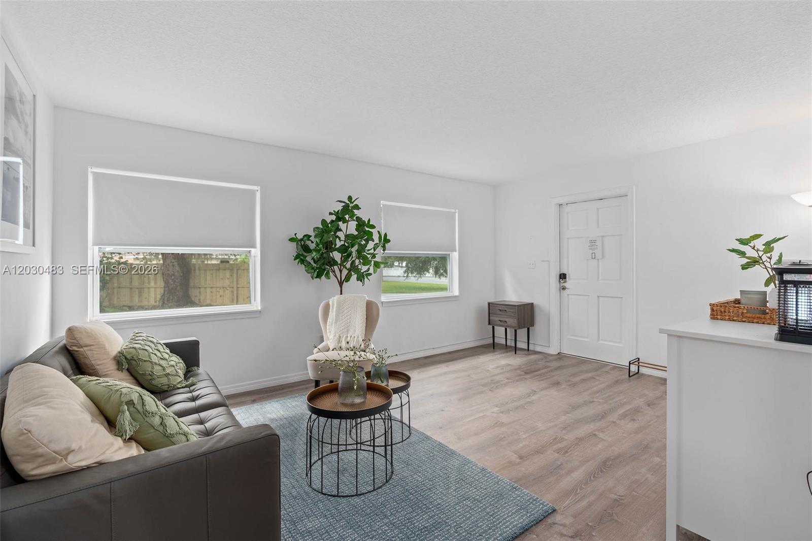 A living room features a dark sofa, two round coffee tables, and light wood flooring — 4255 Wee Street # 4255, Mount Dora FL 32757, MOUNT DORA, FL