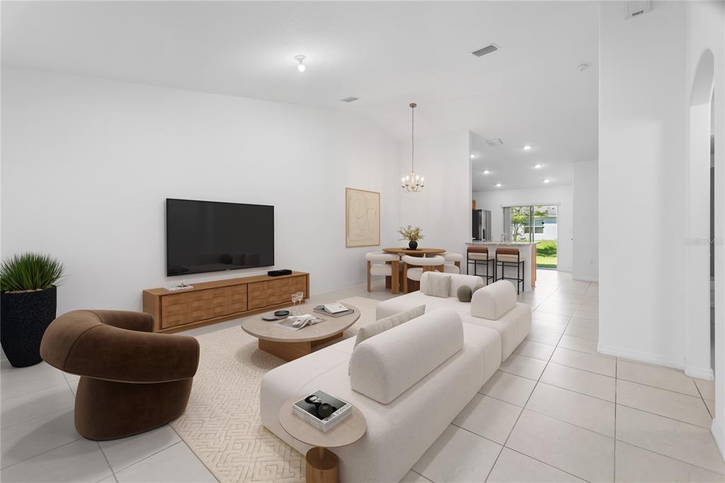 A bright, open-concept living and dining area features white walls, tile flooring, and modern furniture — 10 PONTIAC LANE, PALM COAST, FL