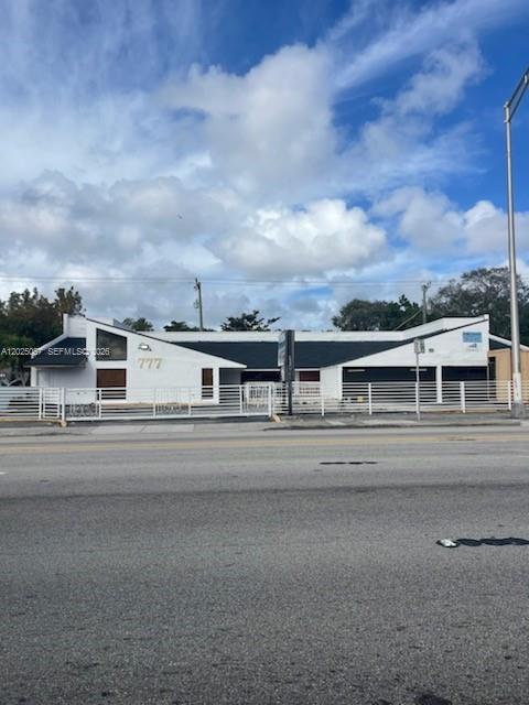 A white commercial building with a fenced front yard sits along a paved road — 777 NE 79th St, Miami FL 33138, MIAMI, FL