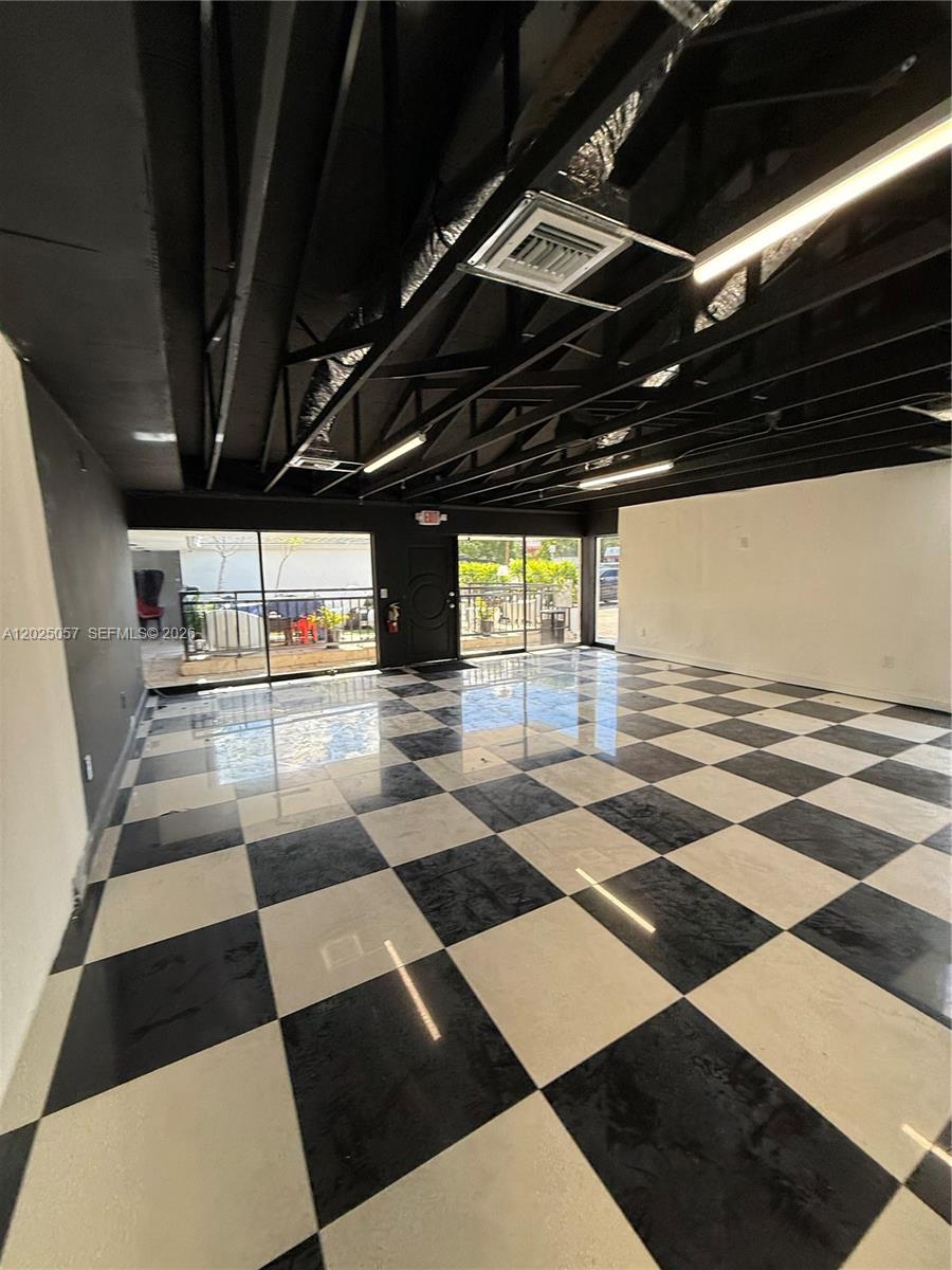 An empty commercial space features a black-and-white checkered floor and an exposed black ceiling — 777 NE 79th St, Miami FL 33138, MIAMI, FL
