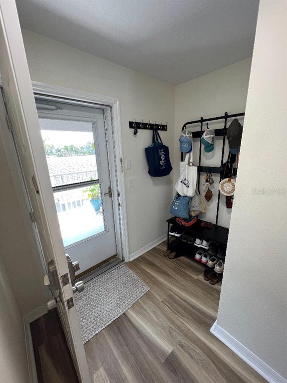 An entryway features wood-look flooring, a coat rack, a shoe storage bench, and a glass door — 9485 HAMLIN BOULEVARD UNIT 8, SEMINOLE, FL