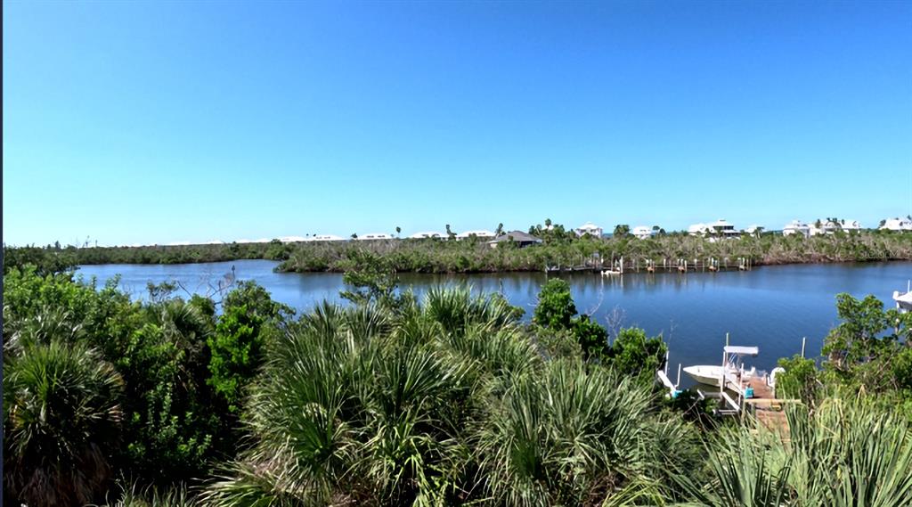 A view of a calm waterway surrounded by lush vegetation with a small private dock — 10049 HEL-LEW COURT, PLACIDA, FL