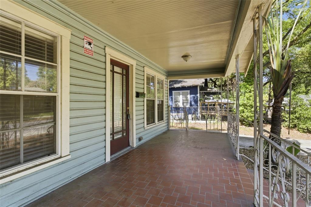 A covered front porch with light blue siding, a brown door, and tiled flooring — 917 E 26TH AVENUE, TAMPA, FL