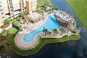 An aerial view shows a resort-style swimming pool with a pirate ship feature and deck — 8100 POINCIANA BOULEVARD UNIT 2106, ORLANDO, FL