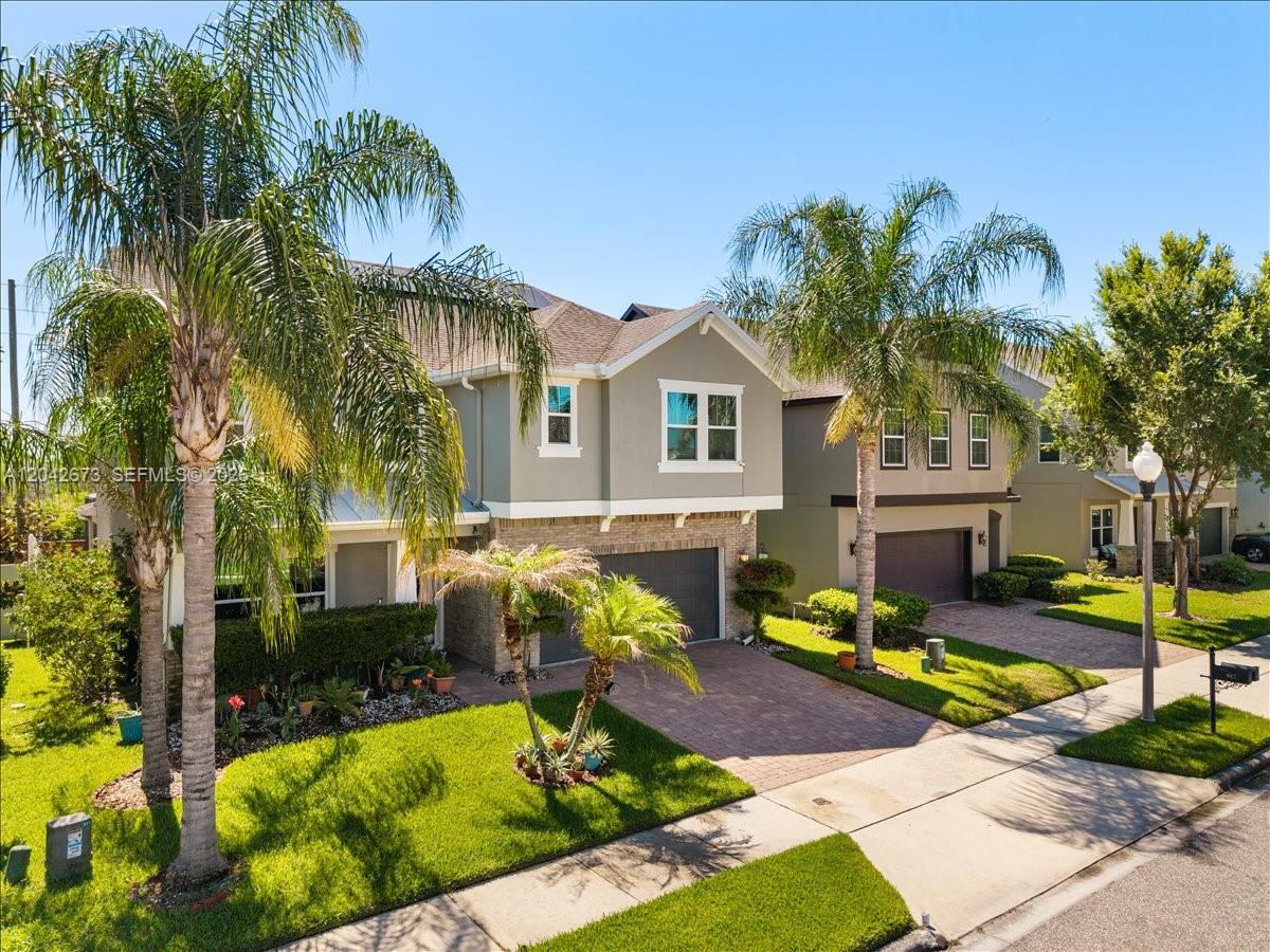 A two-story suburban house with a paved driveway, green lawn, and palm trees — 617 Marsh Reed Drive, Winter Garden FL 34787, WINTER GARDEN, FL