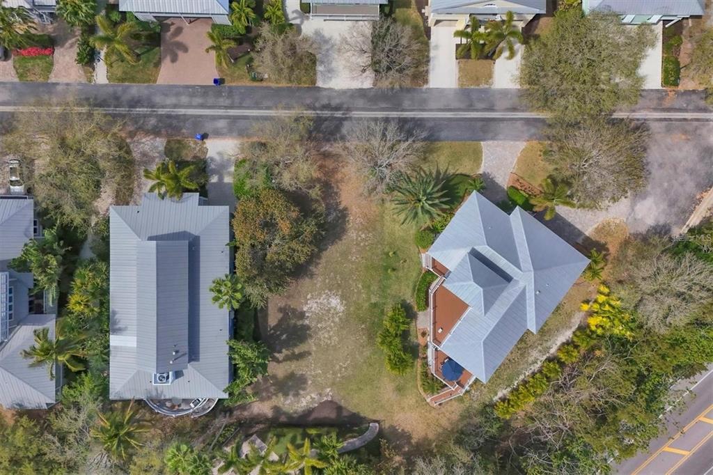 An aerial view shows a vacant lot situated between two houses with metal roofs — 363 FIREHOUSE LANE, LONGBOAT KEY, FL