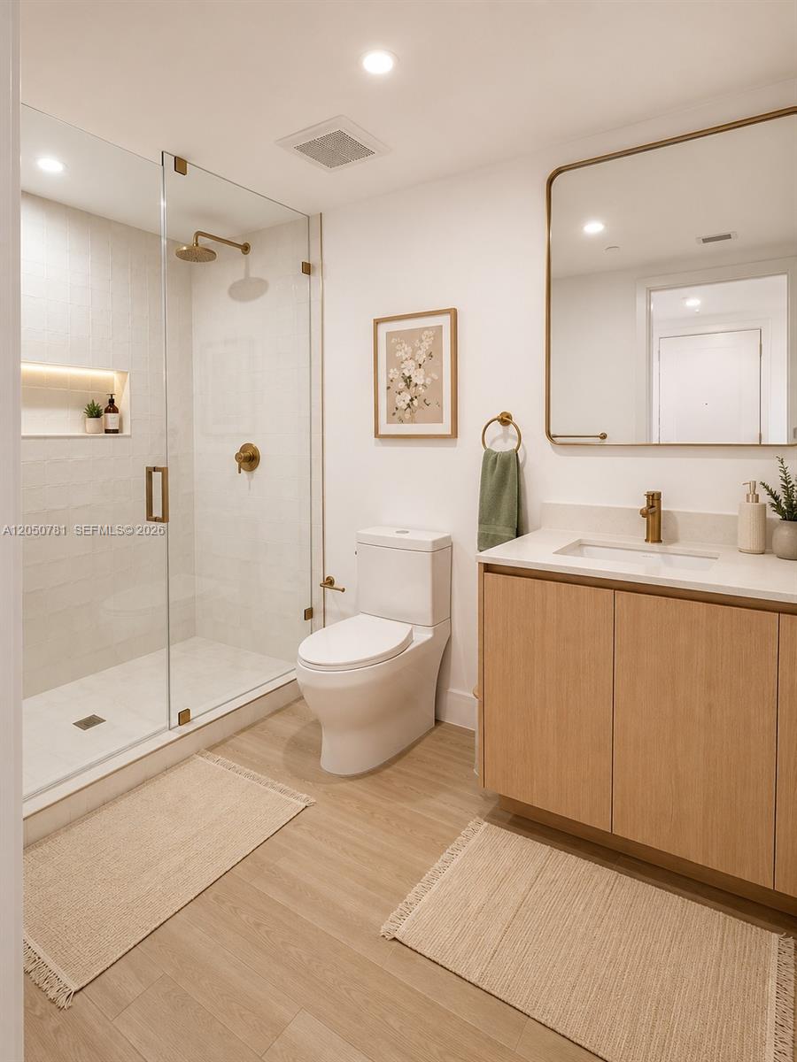 A modern bathroom features a glass-enclosed shower, a white toilet, and a light wood vanity — 90 NE 32 # 713, Miami FL 33137, MIAMI, FL