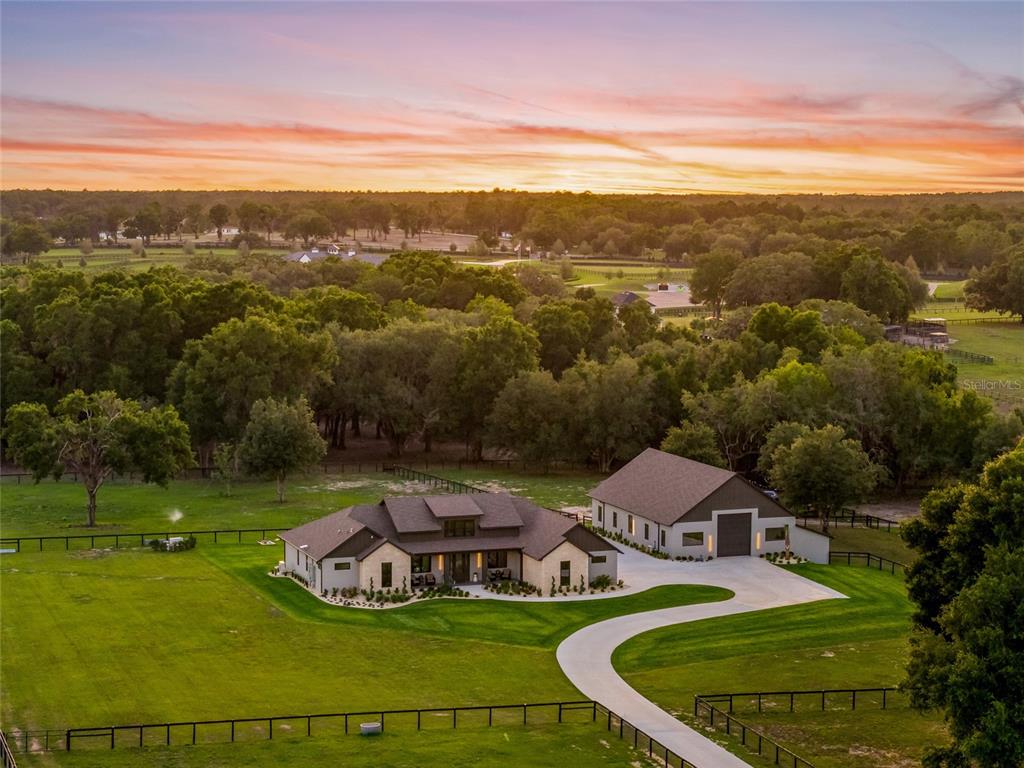 An aerial view shows a modern farmhouse with a large detached garage on a rural lot — 3888 SW 140TH AVENUE, OCALA, FL