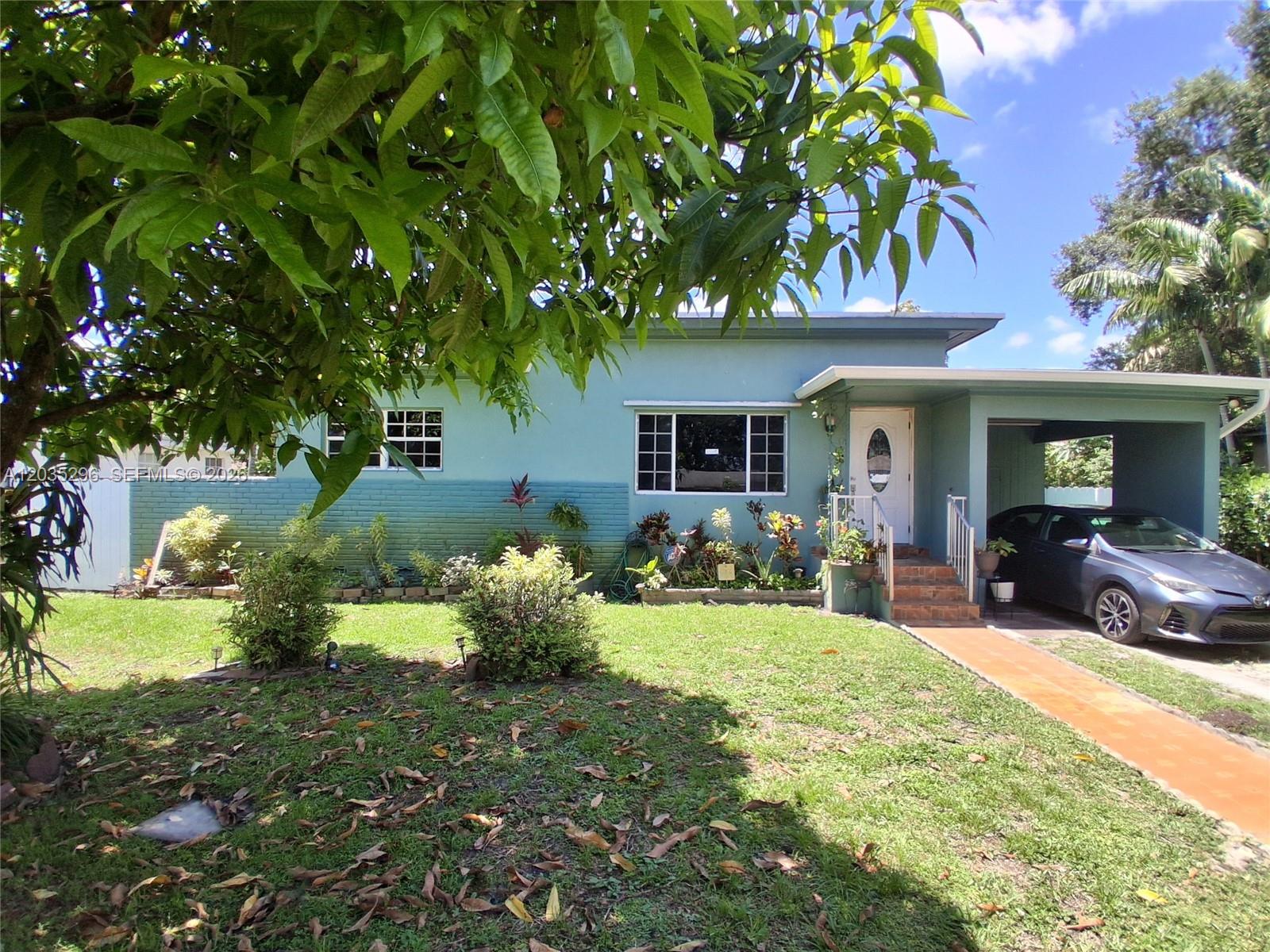 A light blue single-story house features a front lawn, a carport, and a walkway — 220 NW 150th St, Miami FL 33168, MIAMI, FL