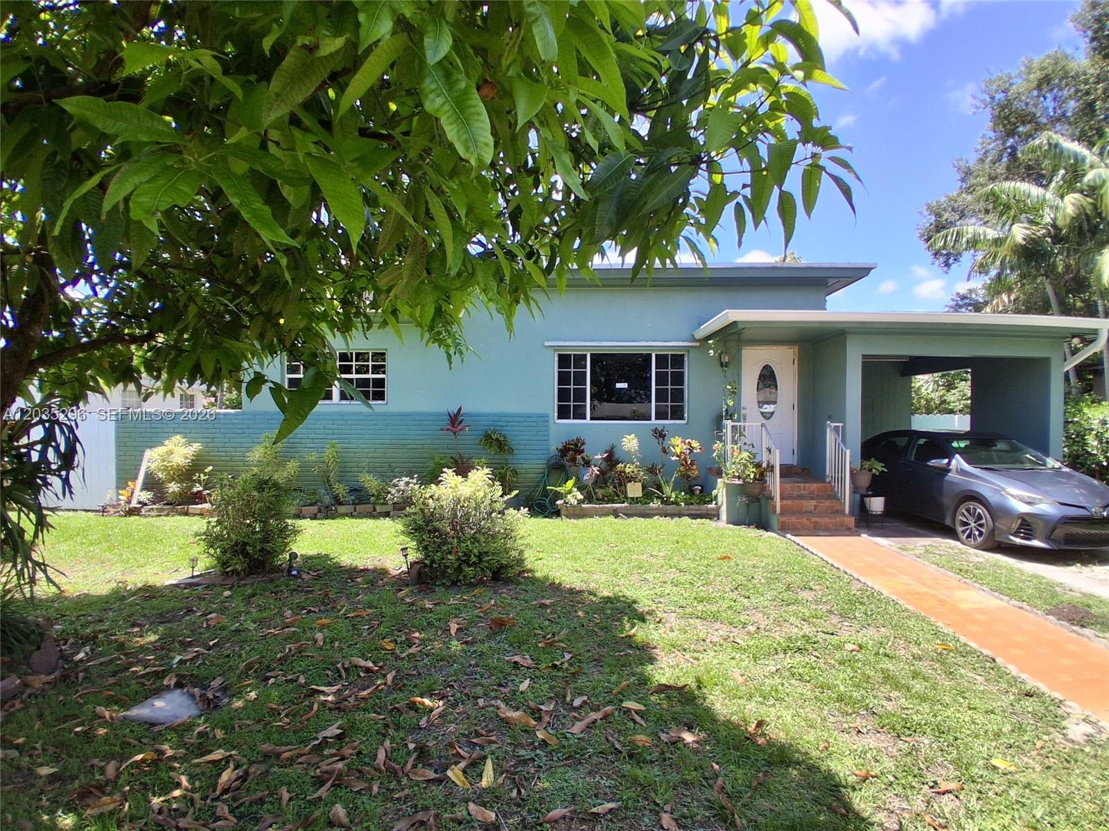 A single-story teal house features a front lawn, a carport, and a paved walkway — 220 NW 150th St, Miami FL 33168, MIAMI, FL