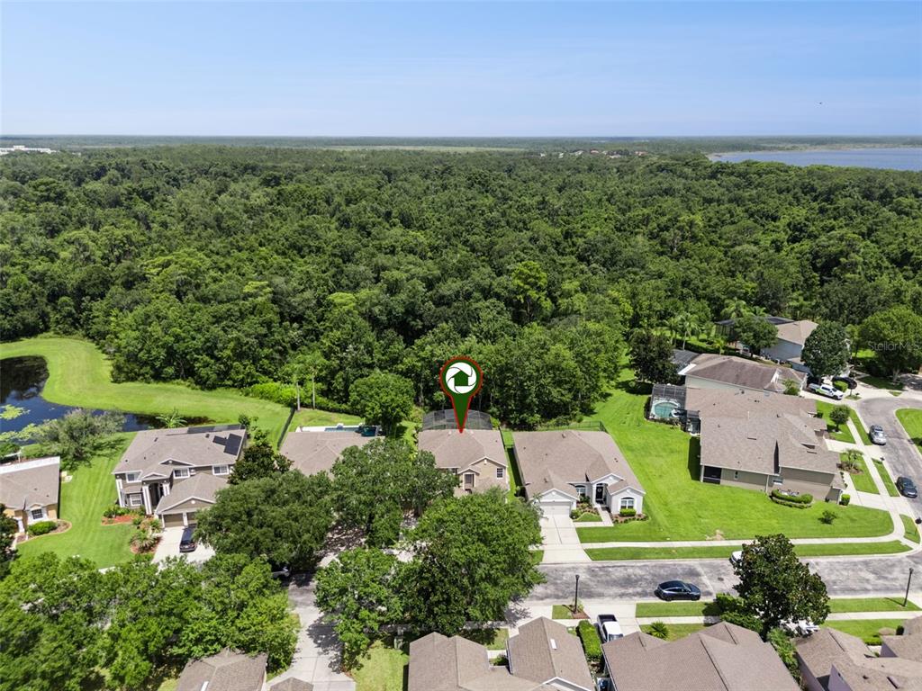 An aerial view shows a residential house with a pool cage in a suburban neighborhood — 10109 MARSH PINE CIRCLE, ORLANDO, FL