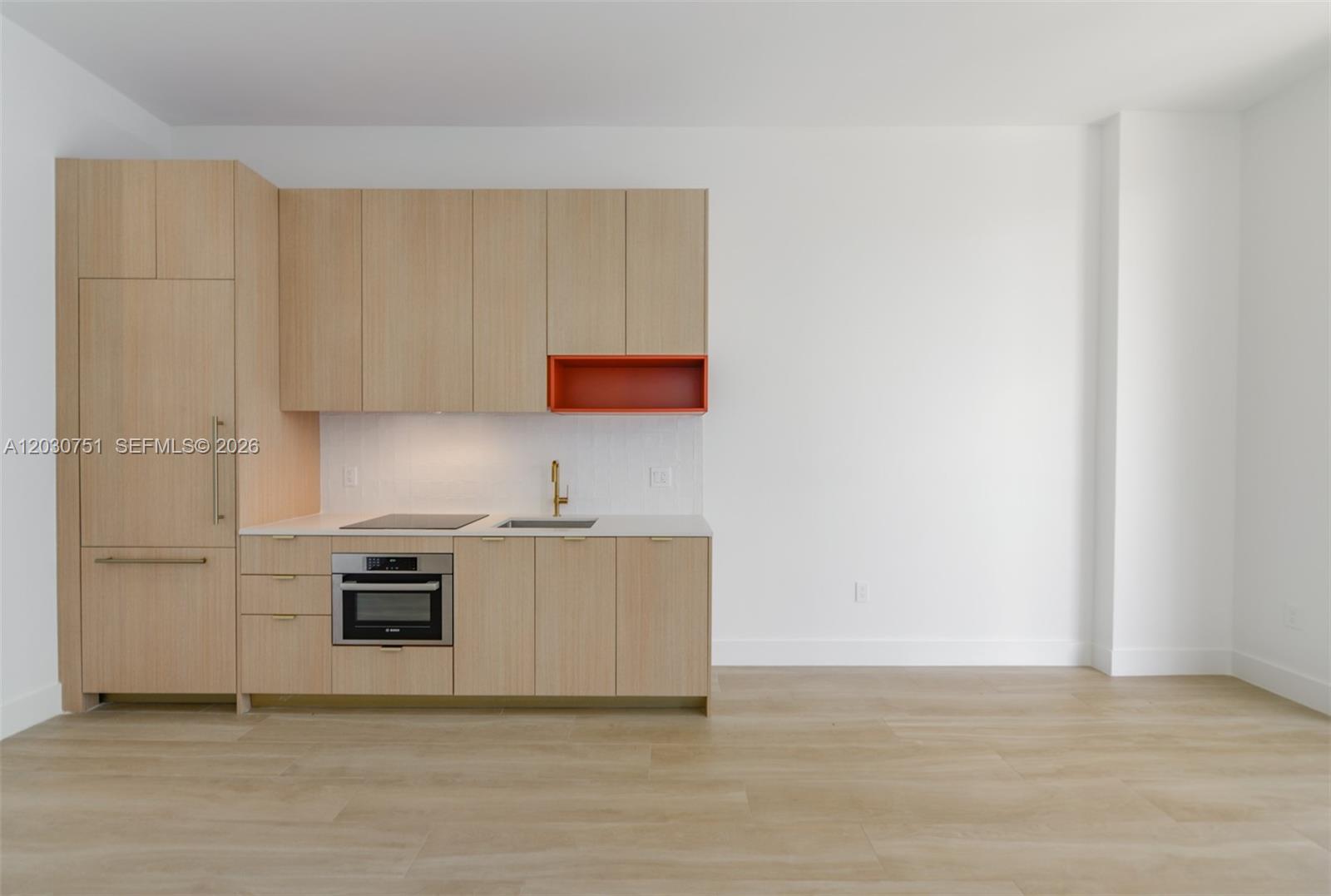 A modern kitchen features light wood cabinetry, a white countertop, and a bright orange open shelf — 90 NE 32 St # 1108, Miami FL 33137, MIAMI, FL