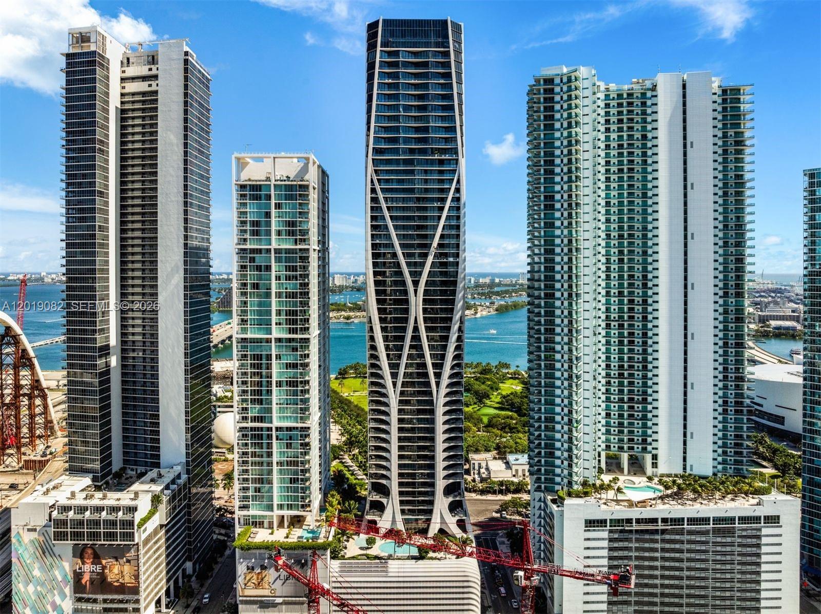 An aerial view shows several modern high-rise residential towers in a dense urban waterfront setting — 1000 Biscayne Blvd # 5101, Miami FL 33132, MIAMI, FL