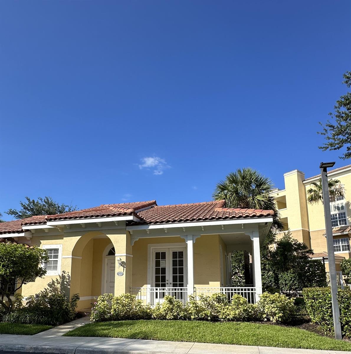 A yellow one-story building with a tiled roof and a covered front porch — 132 Mangrove Bay Way, Jupiter FL 33477, JUPITER, FL