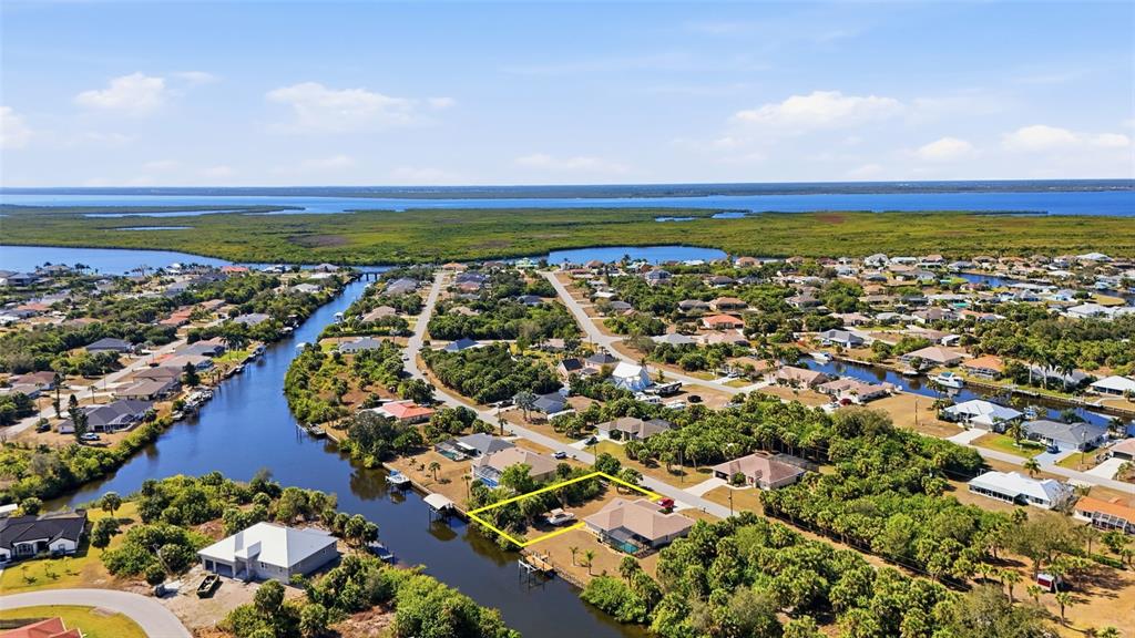 An aerial view shows a residential property highlighted in yellow along a canal — 4250 LIBRARY STREET, PORT CHARLOTTE, FL