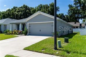 A light gray single-story house with a two-car garage and a concrete driveway — 3882 WILLOW RIDGE DRIVE, LAKELAND, FL