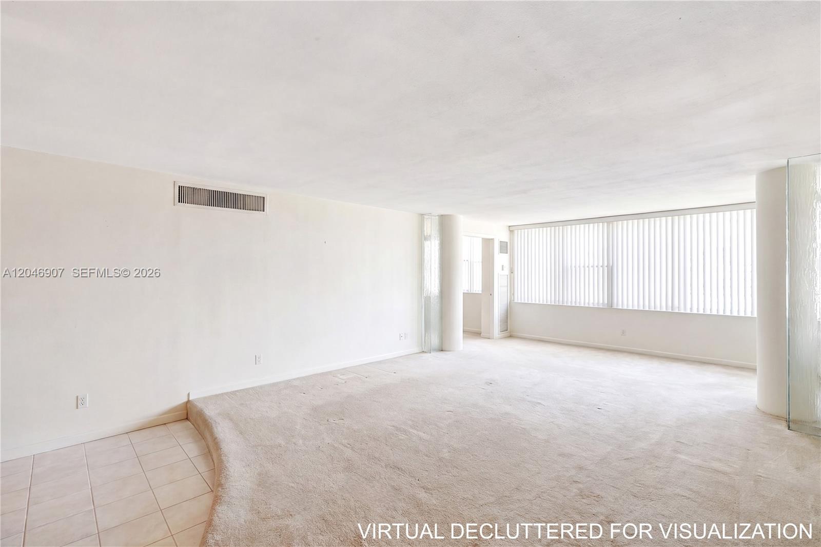 An empty living room features beige carpeting, a tiled entryway, and floor-to-ceiling windows with blinds — 5005 Collins Ave # 1224, Miami Beach FL 33140, MIAMI BEACH, FL
