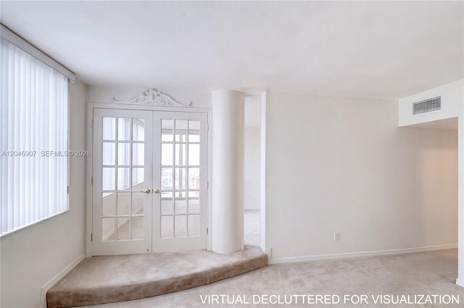 A carpeted room features a raised platform, French doors, and a white structural column — 5005 Collins Ave # 1224, Miami Beach FL 33140, MIAMI BEACH, FL