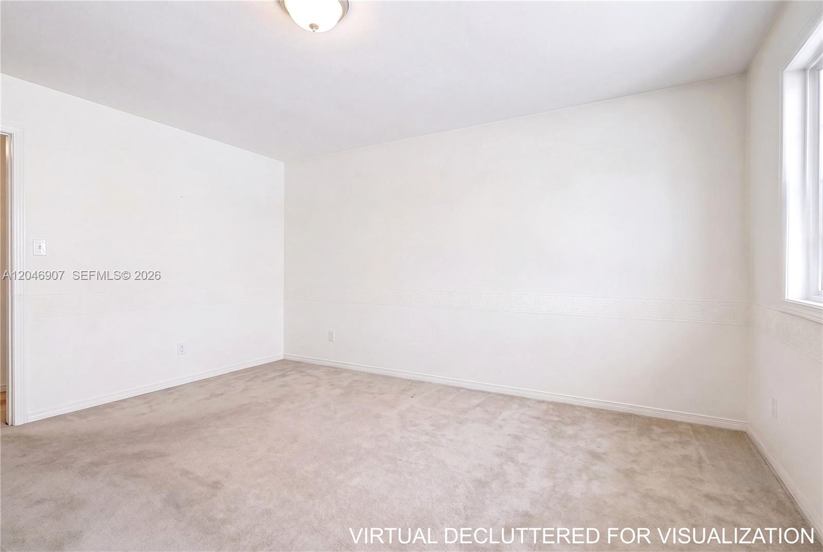 An empty bedroom features white walls with chair rail molding and beige wall-to-wall carpeting — 5005 Collins Ave # 1224, Miami Beach FL 33140, MIAMI BEACH, FL