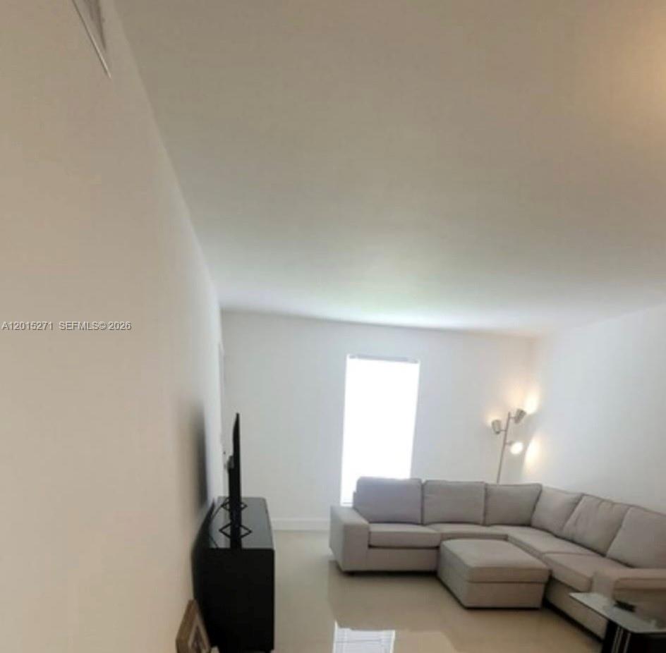 A living room features a light gray sectional sofa, a television stand, and tile flooring — 2341 SW 17th Ave # 2343, Miami FL 33145, MIAMI, FL