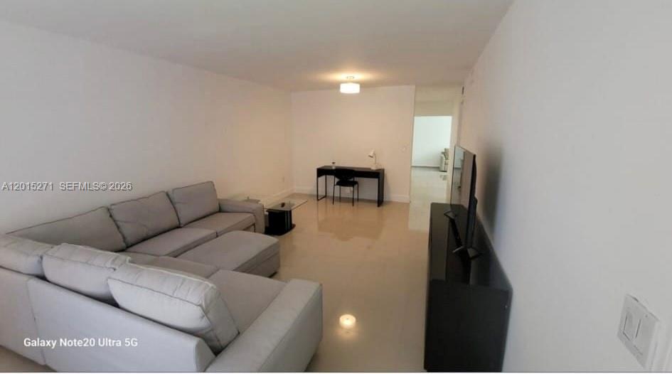 A living room features a large gray sectional sofa, a black desk, and tile flooring — 2341 SW 17th Ave # 2343, Miami FL 33145, MIAMI, FL
