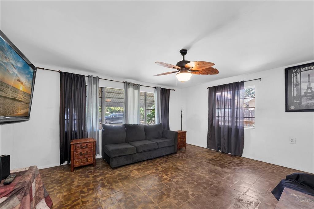 A living room features a dark gray sofa, tile flooring, and a ceiling fan — 1846 51ST STREET S, GULFPORT, FL