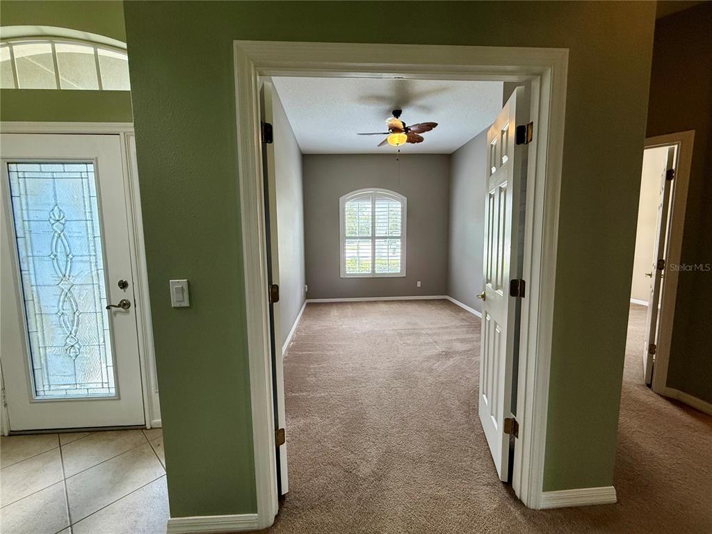 A view from a tiled entryway into a carpeted room with a ceiling fan — 5126 MAJESTIC WOODS PL, SANFORD, FL