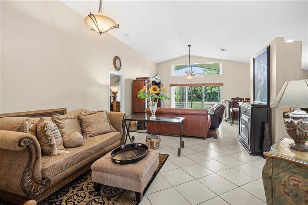 A living room features beige tile floors, a tan sofa, and a vaulted ceiling — 6358 Westchester Club Drive, Boynton Beach FL 33437, BOYNTON BEACH, FL