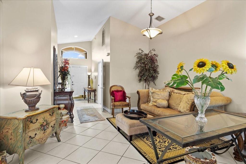 A living room with tile floors, a glass coffee table, and a sofa with sunflowers — 6358 Westchester Club Drive, Boynton Beach FL 33437, BOYNTON BEACH, FL