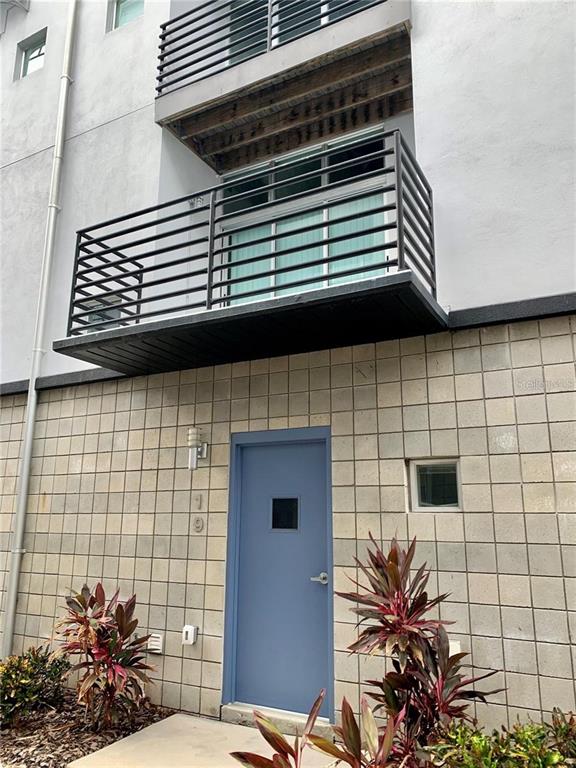 The exterior of a building features a blue door, a metal balcony, and concrete blocks — 5008 S MACDILL AVENUE UNIT 19, TAMPA, FL