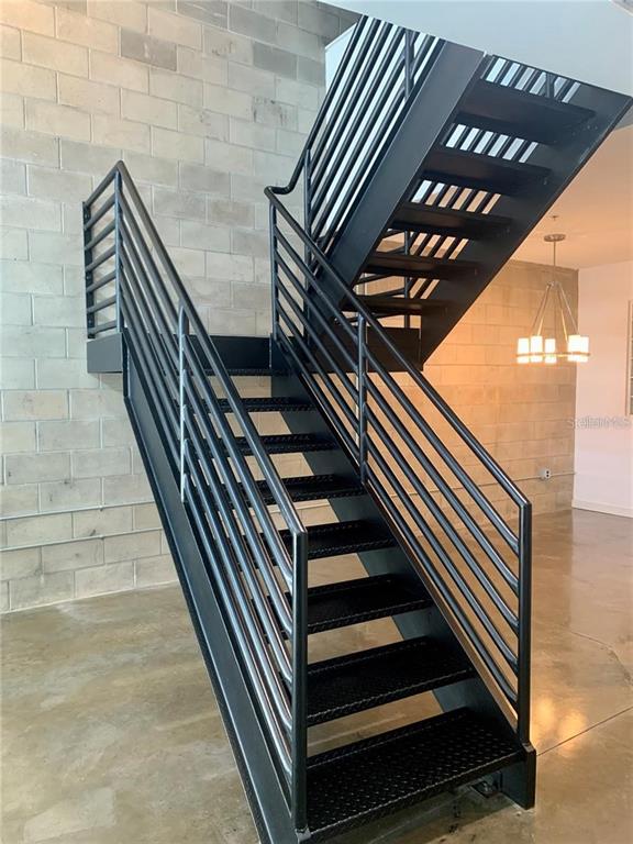 A black metal staircase with diamond-plate treads stands against a gray concrete block wall — 5008 S MACDILL AVENUE UNIT 19, TAMPA, FL