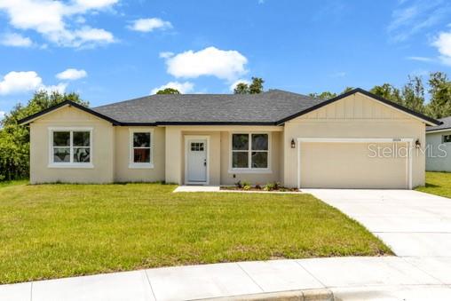 A single-story house with a beige stucco exterior, a dark roof, and a two-car garage — 2524 MAXIMUS COURT, DELTONA, FL