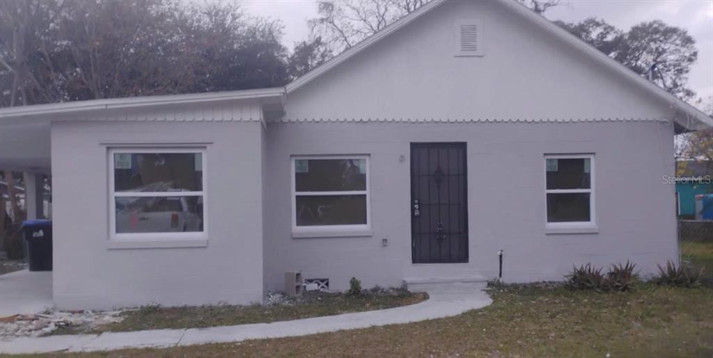 A single-story house with a light gray exterior, a front door with a security gate, and new windows — 110 N GOLDWYN AVENUE, ORLANDO, FL