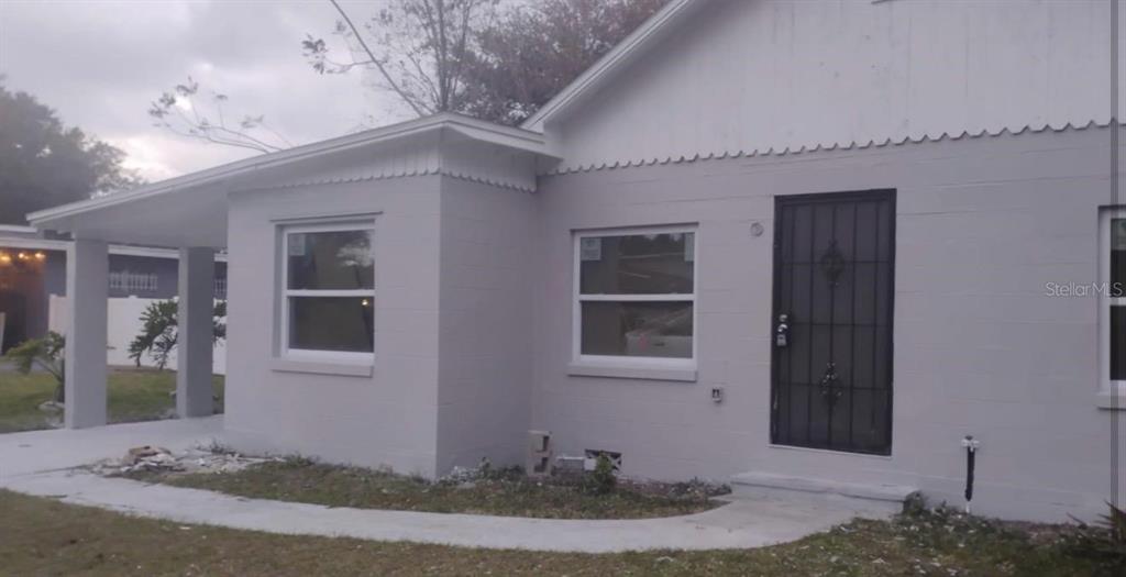 A light gray single-story house with a covered porch and a black security screen door — 110 N GOLDWYN AVENUE, ORLANDO, FL