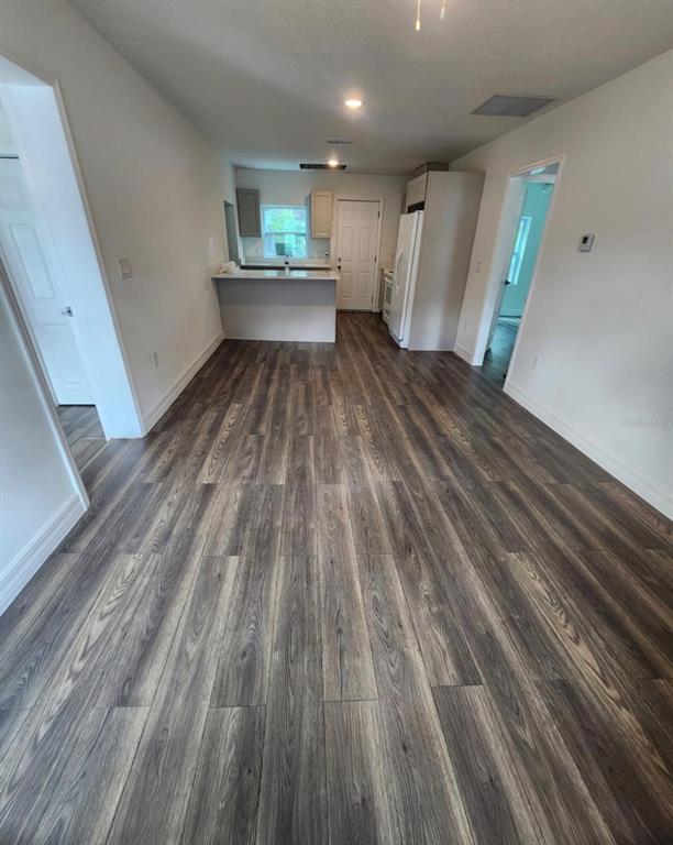 A kitchen with a breakfast bar and wood-look flooring opens into a living area — 110 N GOLDWYN AVENUE, ORLANDO, FL