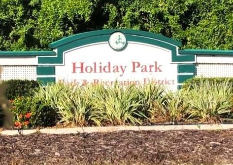 A sign for Holiday Park Park & Recreation District stands in front of green foliage — 6418 KILOHEE COURT, NORTH PORT, FL