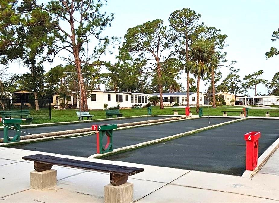 Outdoor shuffleboard courts with numbered scoring markers and benches in a residential community — 6418 KILOHEE COURT, NORTH PORT, FL