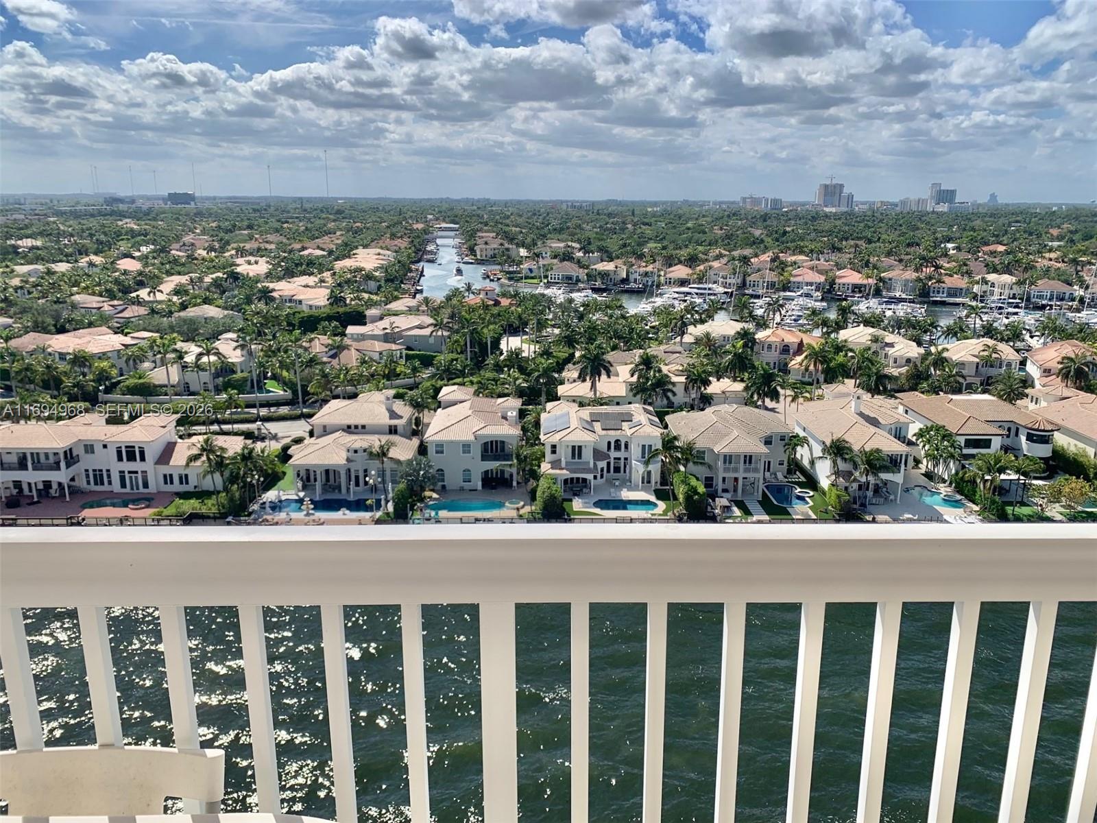 An elevated view from a balcony overlooking a canal, residential homes, and a marina — 1500 S Ocean Dr # 17E, Hollywood FL 33019, HOLLYWOOD, FL