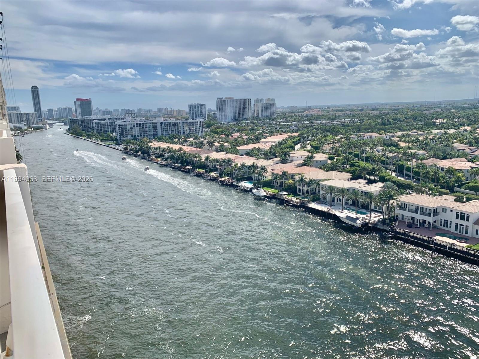 An elevated view of a waterway lined with houses and distant high-rise buildings — 1500 S Ocean Dr # 17E, Hollywood FL 33019, HOLLYWOOD, FL