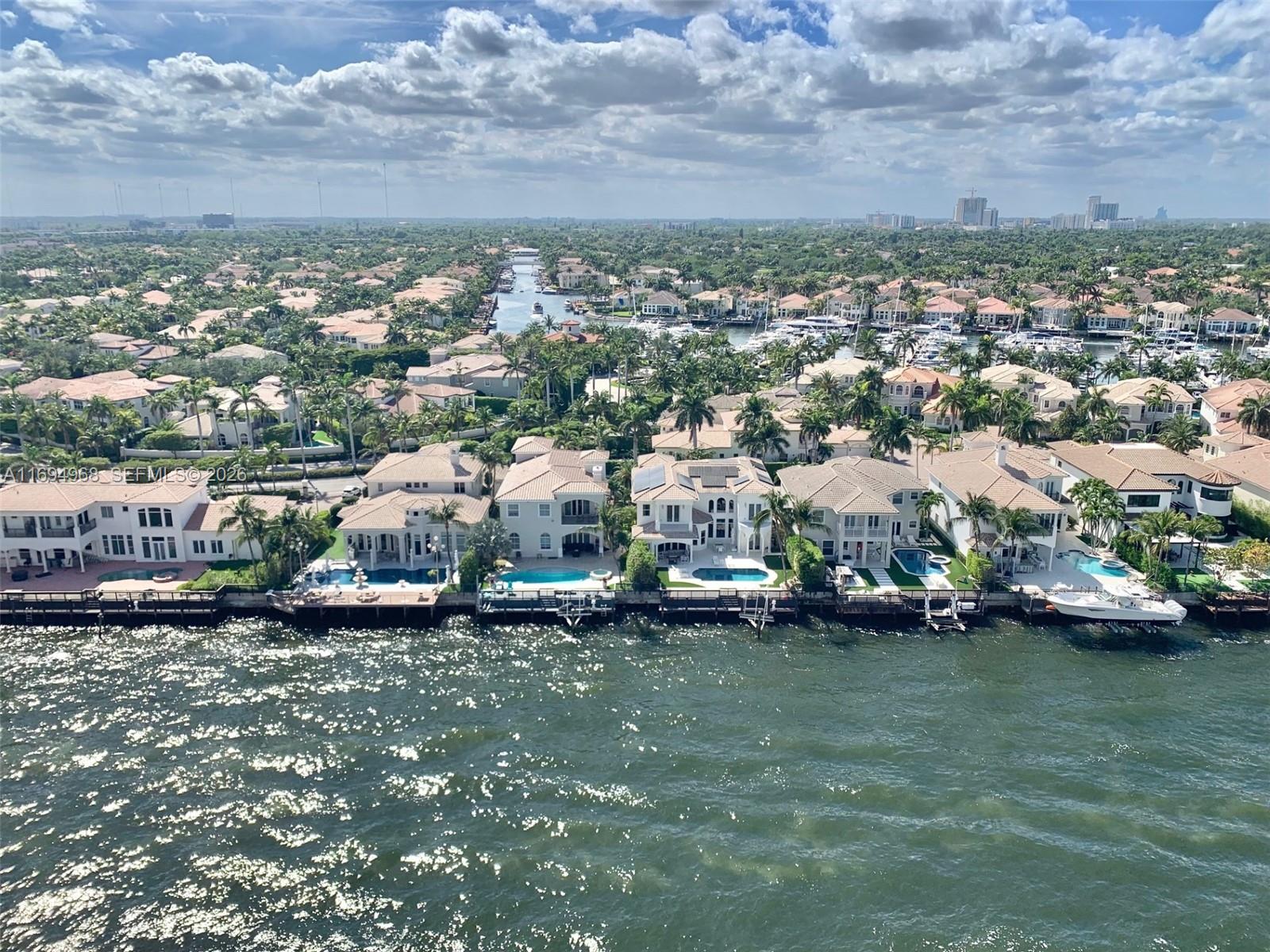 An aerial view shows waterfront houses with swimming pools and private docks along a canal — 1500 S Ocean Dr # 17E, Hollywood FL 33019, HOLLYWOOD, FL