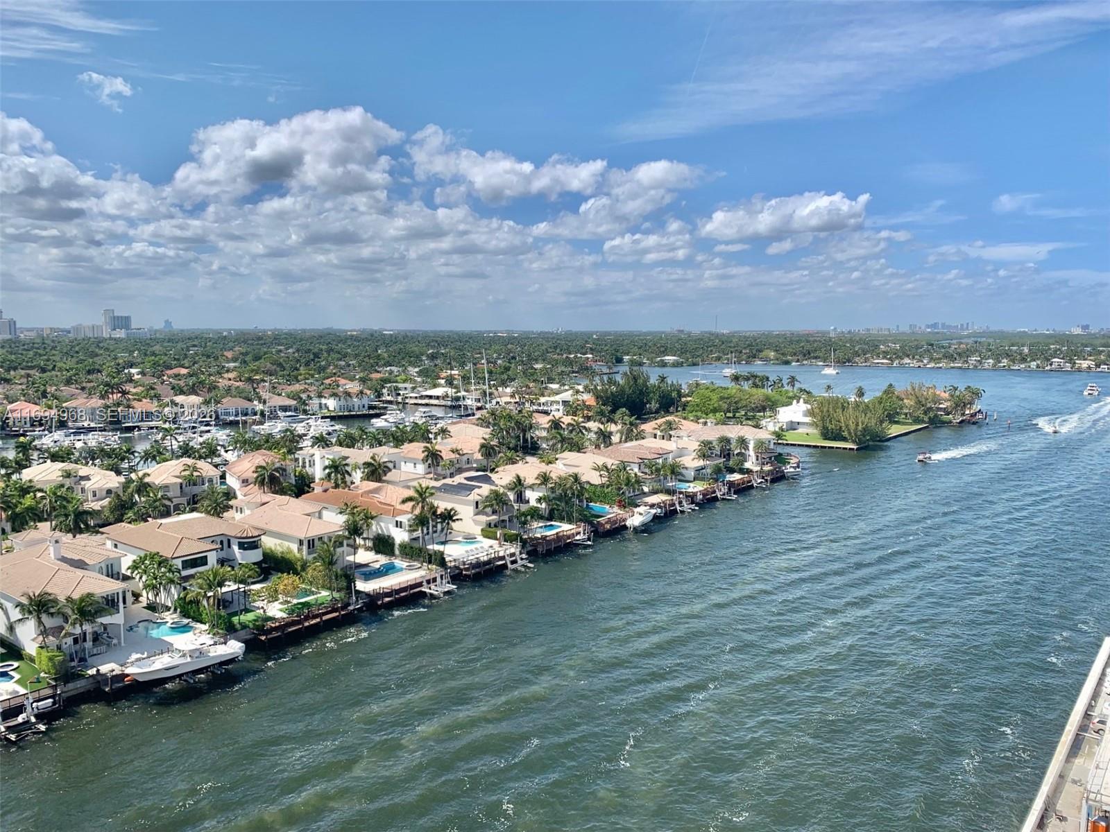 An aerial view shows waterfront homes with private docks along a canal under a cloudy sky — 1500 S Ocean Dr # 17E, Hollywood FL 33019, HOLLYWOOD, FL