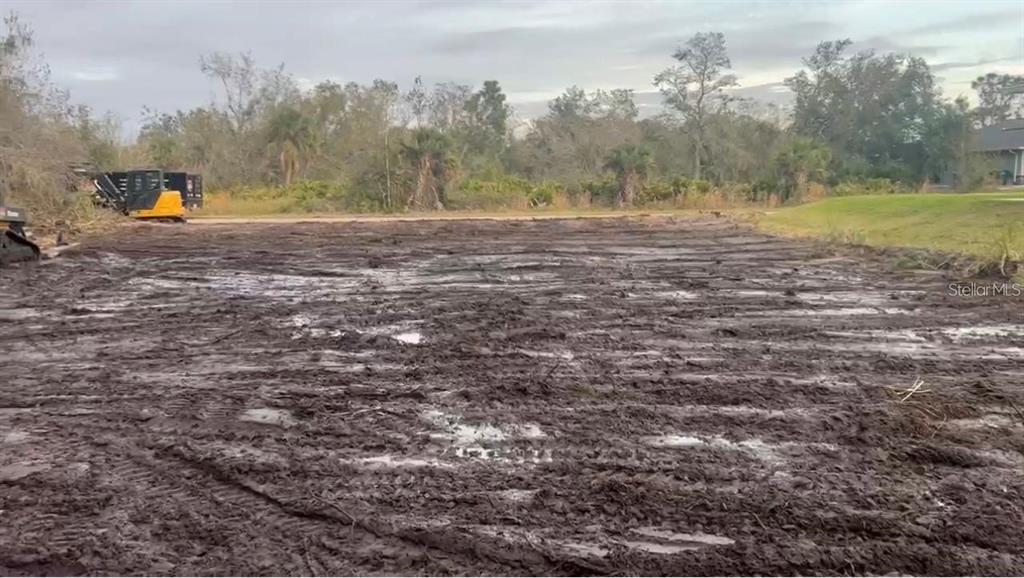 A muddy, cleared construction lot features tire tracks and a piece of heavy machinery nearby — 473 BOUNDS STREET, PORT CHARLOTTE, FL
