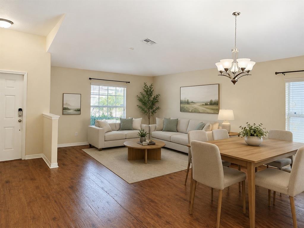 A living and dining area features wood-look flooring, neutral walls, and a light-colored sectional sofa — 15406 FEATHER STAR PLACE, RUSKIN, FL