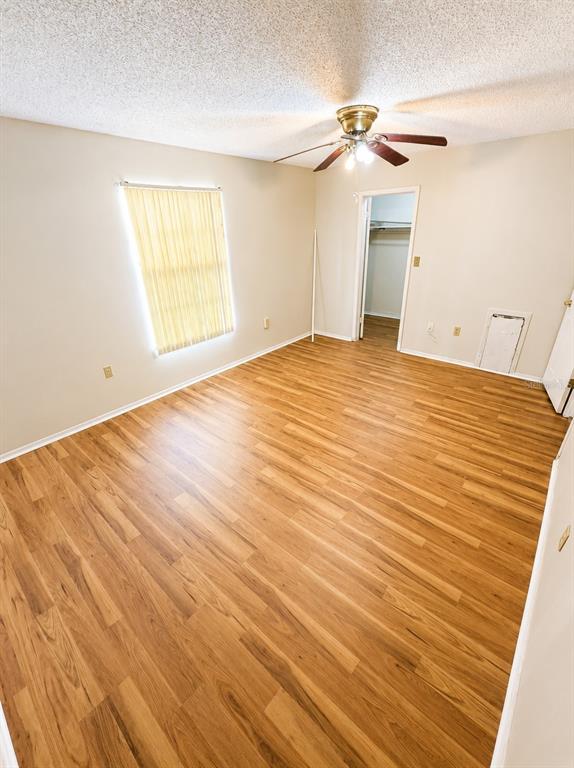 An empty bedroom features light-colored walls, a ceiling fan, a window with blinds, and wood-look flooring — 3510 41ST AVENUE S UNIT 165, ST PETERSBURG, FL