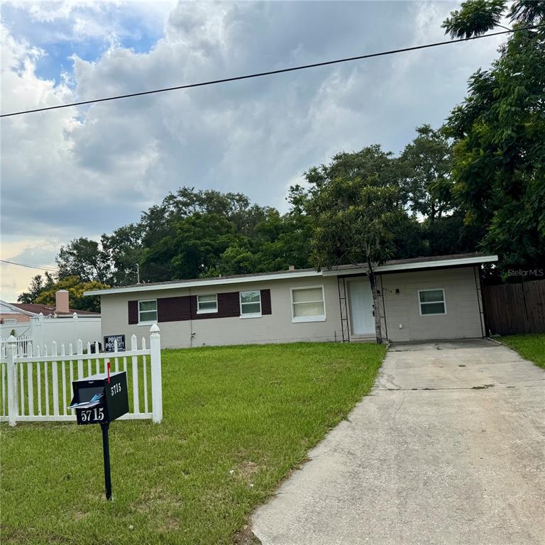 A single-story house with a white fence, a concrete driveway, and a mailbox in front — 5715 ELON DRIVE, ORLANDO, FL